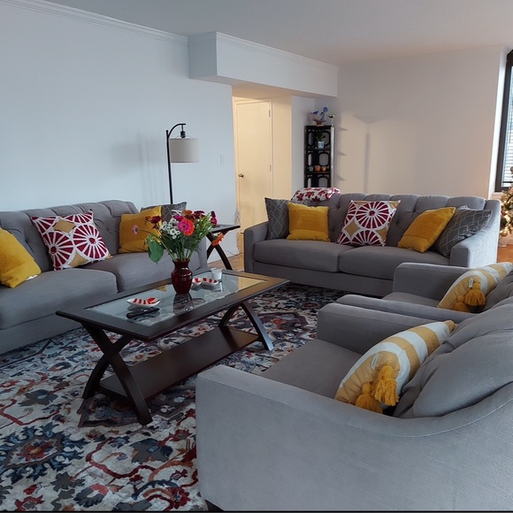 Raymour and Flanigan diamond button-tufting grey couch with textured pillows.